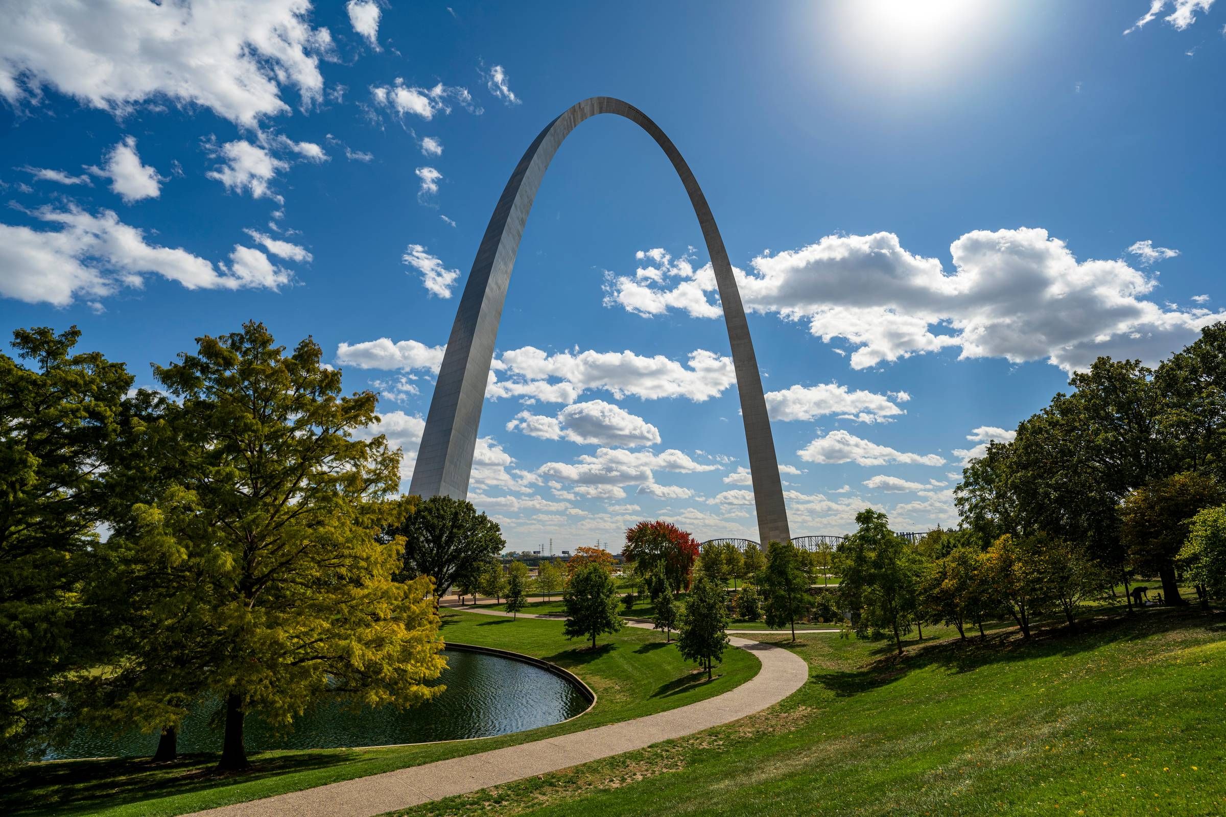 Rockwood Apartments The Gateway Arch in St. Louis stands tall under a sunny, blue sky with scattered clouds and surrounding greenery.